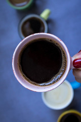 Coffee cup in woman hand, close up, top view.