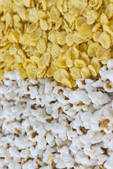 Corn products: cornflakes and popcorn, close-up.