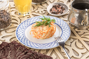 Coleslaw salad with carrot and glass of lemonade on oriental wooden table