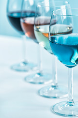 Wine Varieties. Four Glasses of Wine on Table – Red Wine, Rose, White and Blue Wine