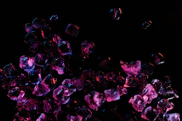 top view of frozen ice cubes with purple lighting isolated on black
