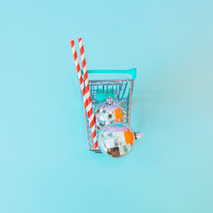 Fototapeta premium Shopping cart full of gifts and Christmas decorations. Minimal, flat lay. Top view