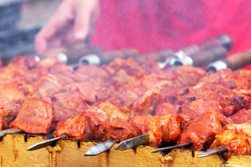 Man fries meat on the grill, picnic. Cooking barbecue on the grill. Barbecue with meat on skewers