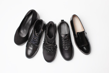 Different black leather women autumn shoes on white background