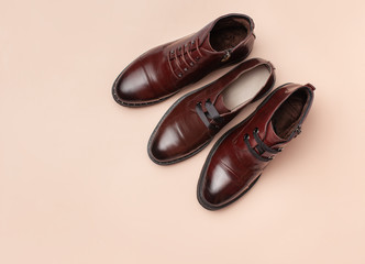 Brown women's leather autumn ankle boots on pink background.