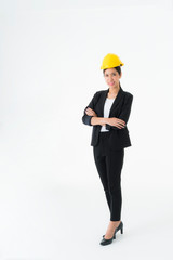 Portrait smiling Asian young engineer woman wearing a black suit black long hair and Yellow Safety helmet standing with arms folded copy space isolated on white background studio Vertical image