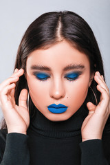 Beauty concept. Young model with blue lips and soft skin after plastic surgery and injections. Female on light background. Woman with makeup after beautician procedures