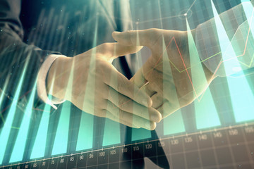 Multi exposure of forex graph on abstract background with two businessmen handshake. Concept of success on stock market