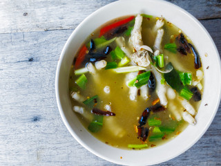 Chicken feet in hot and spicy soup on rustic wood background