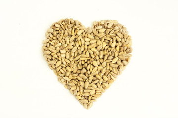 Heart shaped peeled seeds on white background