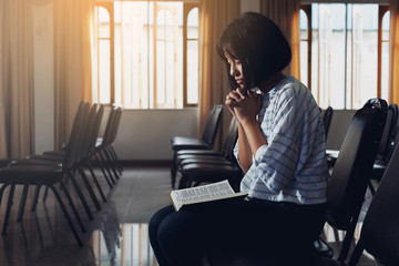 A Girl hand praying with holy bible