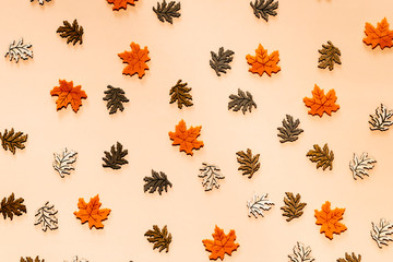 Golden leaves on beige background. Autumn, fall concept.