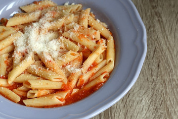 Plate of pasta with homemade tomato sauce. and grated parmesan cheese on top. Selective focus.