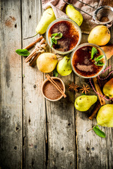 Autumn healthy drinks and snacks. Pear smoothie with cocoa chocolate and spices - cinnamon, anise, with mint leaves. On a rustic wooden background, copy space