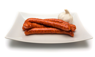 Merguez sausages on a dish isolated on white background.