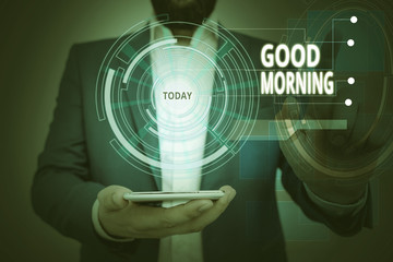 Conceptual hand writing showing Good Morning. Concept meaning A conventional expression at meeting or parting in the morning Male wear formal suit presenting presentation smart device