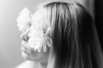 Obraz na płótnie Canvas Blurred portrait of a young girl with flowers in her hair, female dreams and pleasure. Selective soft focus. Black and white.