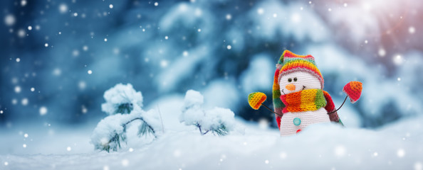 little snowman on soft snow on blue background