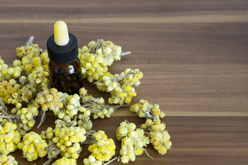 The Helichrysum Arenarium golden grass on the wooden background.