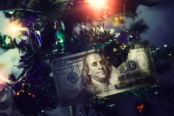 Hundred dollar bills. Money on Christmas tree. Small decorated Christmas tree on a blue background
