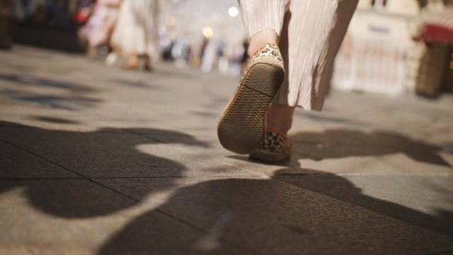 Close-up of feet walking on the street