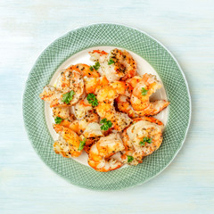 Fired shrimps with fresh parsley leaves, square overhead shot