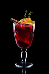 Glass of hot mulled wine isolated on black