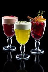 Three goblets of hot mulled wine, grog and punch isolated on black