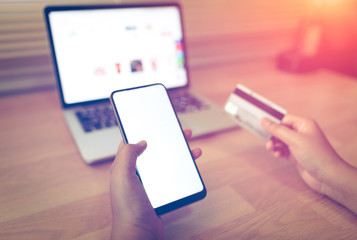  Woman hands holding credit card and using laptop smart phone Online shopping