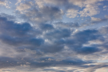 The sky at sunset. Cumulus clouds lit by the rays of the setting sun.