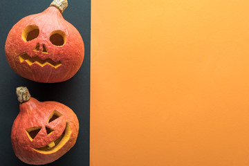 top view of carved Halloween pumpkins on orange and black background