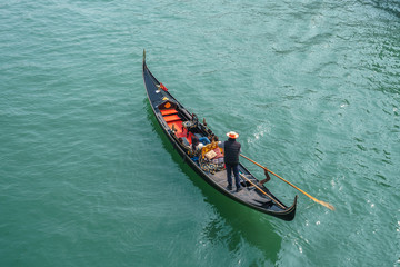 Tourists in gondolas on canal of Venice.