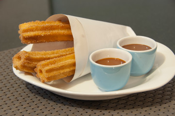 Churros con chocolate served in a restaurant.