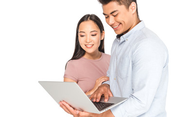 handsome asian man using laptop near smiling girlfriend isolated on white