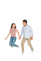 happy asian man and woman jumping while holding hands on white background