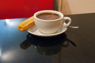 Churros con chocolate served in a restaurant.