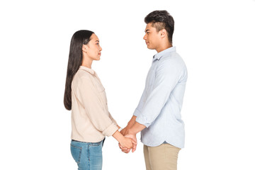 happy asian couple holding hands and looking at each other isolated on white