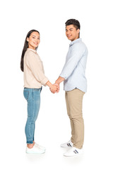 happy asian couple holding hands and smiling at camera on white background