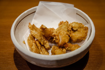 Blurred soft of fried chicken in white bowl.