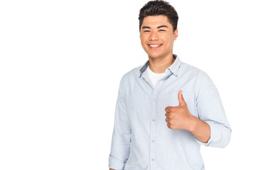 happy asian man showing thumb up while smiling at camera isolated on white