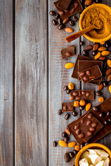 Cook homemade chocolate with bars, nuts, coffee beans on wooden background top view mock up