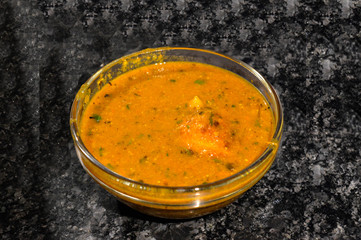 Egg curry in bowl isolated on black marble with chilli.