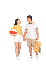 Fototapeta na wymiar young asian man with backpack holding hands with cheerful girlfriend with beach ball on white background