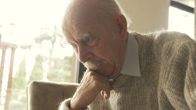 Pensive elder senior man looking away feel upset, thoughtful melancholic older retired gray haired grandpa suffer from sorrow grief loneliness, sad grandfather widower alone at home, close up view