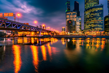 Beautiful cityscape panorama with illuminated bridge and skyscrapers at night