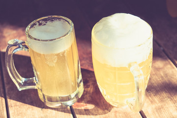 Close-up two cold beers with foam and drops.