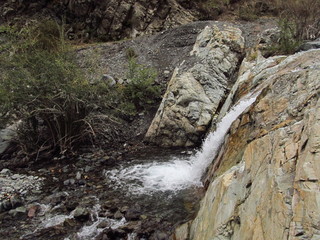water running among the stones making a little waterfall