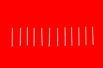 Symbol of danger with matches on red background top view
