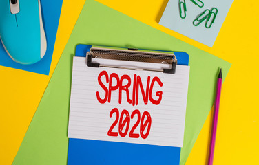 Word writing text Spring 2020. Business photo showcasing time of year where flowers rise following winter season Clipboard striped sheets marker clips notepad mouse colored background