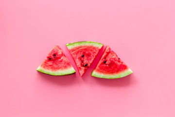 Slices of watermelon on pink background top view